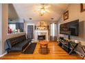 Cozy living room features hardwood floors, a fireplace, and modern entertainment setup at 7617 Lakemoor Dr, Riverdale, GA 30296
