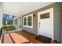 Inviting covered porch with wooden deck flooring and a white front door at 1947 Maywood Nw Pl, Atlanta, GA 30318