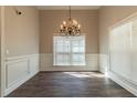 Elegant dining area with chandelier, wainscoting, and hardwood flooring at 405 Rabbits Run, Fayetteville, GA 30214