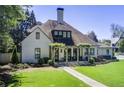 Charming home featuring a covered front porch with verdant landscaping and manicured lawn at 406 Whitmore Nw Dr, Atlanta, GA 30305