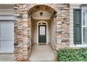 Close up of stone archway and front door featuring glass pane details at 6245 Milton Dr, Cumming, GA 30041