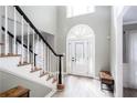 Bright foyer featuring a staircase with black and white banisters and a front door with decorative glass at 4955 Day Lily Nw Way, Acworth, GA 30102