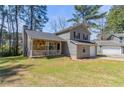Charming home with a stone porch, gray siding, and a lush front yard at 971 Lake Watch Ct, Stone Mountain, GA 30088
