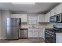 Modern kitchen featuring stainless steel appliances, white cabinets, and neutral countertops at 971 Lake Watch Ct, Stone Mountain, GA 30088
