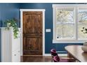Inviting entry featuring a stained wood door, white trim, stylish hardware, and navy blue walls at 1479 Hartford Sw Ave, Atlanta, GA 30310