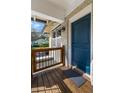 Covered front porch entry featuring a custom dark blue door, wooden deck, and metal railing at 1479 Hartford Sw Ave, Atlanta, GA 30310