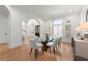 Formal dining room featuring hardwood floors, arched windows, and glass-top table at 303 Rolling Rock Se Rd, Marietta, GA 30067
