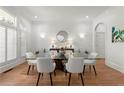 Bright formal dining room with hardwood floors, white trim, and glass table at 303 Rolling Rock Se Rd, Marietta, GA 30067