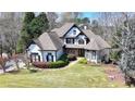 Eye-catching two-story home with black accents, multiple gables and mature trees in the front yard at 4852 Jacobs Cove Pt, Buford, GA 30519