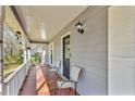 Covered front porch with seating area and decorative exterior lighting fixture at 8698 Twin Oaks Dr, Jonesboro, GA 30236