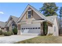 View of a two-car garage with decorative windows and a manicured front yard at 407 Black Fox Dr, Locust Grove, GA 30248