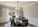 Formal dining room featuring hardwood floors, a stylish chandelier, and natural light at 12600 Silver Fox Court, Roswell, GA 30075