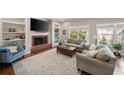 Cozy living room with a brick fireplace, built-in bookshelves, and comfortable seating at 12600 Silver Fox Court, Roswell, GA 30075