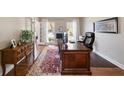 Inviting home office space featuring a large wooden desk, hardwood floors, and natural light at 12600 Silver Fox Court, Roswell, GA 30075