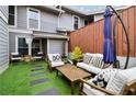 Cozy patio with artificial turf, wooden furniture, and a shaded umbrella for outdoor relaxation at 4988 Meadow Ln, Marietta, GA 30068
