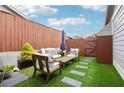 Inviting outdoor patio featuring stylish furniture, a wooden table and lush artificial turf at 4988 Meadow Ln, Marietta, GA 30068