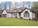 Well-maintained brick house boasts a lush lawn, inviting entryway, and convenient two-car garage at 5233 Hayden Farms Dr, Powder Springs, GA 30127