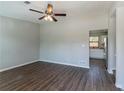 Bright living room featuring sleek, dark laminate flooring and a modern ceiling fan with an open view to the kitchen at 5224 Sweet Air Ln, Stone Mountain, GA 30088