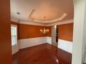 Elegant dining room featuring dark hardwood floors, rust colored walls, wainscotting, and stylish chandelier at 3963 Lucas Ln, Ellenwood, GA 30294