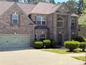 Charming two-story brick home with a well-manicured lawn and attached two-car garage at 3963 Lucas Ln, Ellenwood, GA 30294