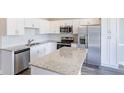 Modern kitchen boasts white cabinets, stainless steel appliances, and a stylish island at 417 Flowery Branch Ct, Villa Rica, GA 30180