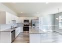 Bright kitchen featuring white cabinetry, granite countertops, and stainless steel appliances at 417 Flowery Branch Ct, Villa Rica, GA 30180