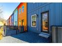 Brightly painted townhome with a small gravel yard, modern exterior lighting, and a fenced patio at 140 Color Cir, Atlanta, GA 30317