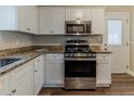 Modern kitchen featuring stainless steel appliances, granite countertops, and white cabinetry at 3475 Glensford Dr, Decatur, GA 30032