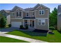 Inviting two-story home with a manicured lawn, enhanced by lush greenery and an attached two-car garage at 1218 Lanier Springs Dr, Buford, GA 30518