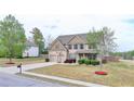 Lovely two-story home featuring a well-manicured lawn, two car garage, and a basketball hoop at 9 Oatgrass Dr, Grayson, GA 30017