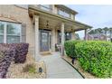 Inviting front porch with decorative columns, landscaping, and an outdoor seating area at 9 Oatgrass Dr, Grayson, GA 30017