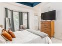 Modern main bedroom with tray ceiling, bay window, hardwood dresser, and serene color palette at 951 Glenwood Se Ave # 3104, Atlanta, GA 30316