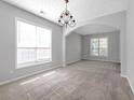 Inviting living room featuring an archway, chandelier and neutral walls, bathed in natural light at 145 Silver Mine Trl, Austell, GA 30168