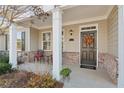 Charming covered porch with a cozy seating area and a decorative wreath on the front door at 2565 Grapevine Cir # 103, Cumming, GA 30041