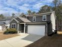 Charming two-story home with gray siding, white trim, a two car garage, and a well-manicured lawn at 5 Dew Drop Pt, Dallas, GA 30157