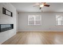 Bright living room with sleek fireplace, light wood floors, and two large windows at 5 Dew Drop Pt, Dallas, GA 30157