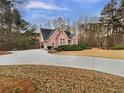 Beautiful brick home with a long driveway, attached garage, and lush green landscaping at 2688 Kelly Cove Dr, Buford, GA 30519