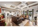 Spacious living room featuring hardwood floors, coffered ceilings and a stone fireplace at 4030 Amberhill Cir, Cumming, GA 30040
