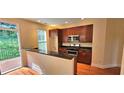 Bright kitchen boasts stainless appliances, wood floors, and a deck with wooded view at 5905 Brookside Oak Cir, Norcross, GA 30093