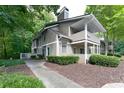 Exterior view of condo featuring neutral siding, covered porch, and mature trees for a serene setting at 1501 Wynnes Ridge Cir, Marietta, GA 30067