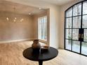 Inviting room with a modern chandelier, hardwood floors, and views of the outdoors through black framed windows at 2515 Habersham Rd, Atlanta, GA 30305