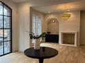 Bright living room with a unique chandelier, fireplace, wet bar, and large black framed windows at 2515 Habersham Rd, Atlanta, GA 30305