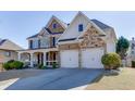 Stunning two-story home showcasing a stone and brick exterior, an inviting porch, and a spacious driveway at 2546 Summer Song Way, Buford, GA 30519
