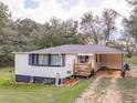 A charming one-story home with a cozy front porch and a carport area at 1202 Coan Dr, Locust Grove, GA 30248