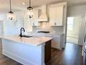 Island kitchen with quartz countertops, dark hardware, stainless steel appliances and pendant lighting at 1826 Butterfly Way, Marietta, GA 30066