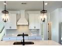 Bright kitchen features quartz countertops, white cabinets, stylish backsplash, and elegant pendant lighting at 1826 Butterfly Way, Marietta, GA 30066