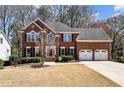 Beautiful two-story brick home with mature landscaping and a three-car garage at 1180 Mayfield Manor Dr, Alpharetta, GA 30009