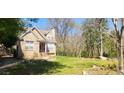 Cozy brick home featuring a well-manicured lawn, mature trees and driveway on a sunny day at 120 Johnson Nw Rd, Atlanta, GA 30318