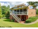Expansive backyard featuring a screened porch with stairs leading down to a patio and lush green lawn at 981 Cranbrook Glen Ln, Snellville, GA 30078
