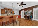 Entertaining space with a full bar, hardwood floors, and a decorative brick wall at 5355 Avonshire Ln, Cumming, GA 30040